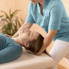 Fizjoterapeuta delikatnie masuje mięsień mostkowy pacjentki, przynosząc ulgę i relaks.