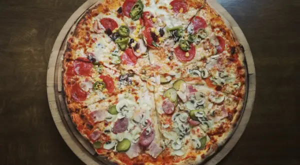 Apetyczna pizza z salami, jalapeno, pieczarkami i ogórkiem. Idealna na wieczór, choć warto pamiętać o jej pizza kcal.