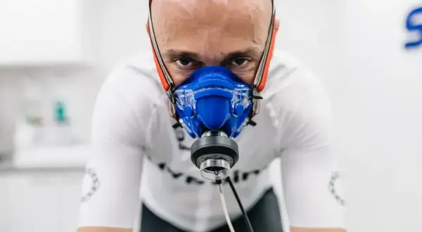 Mężczyzna w masce do testów wysiłkowych, badający swoje VO2max.