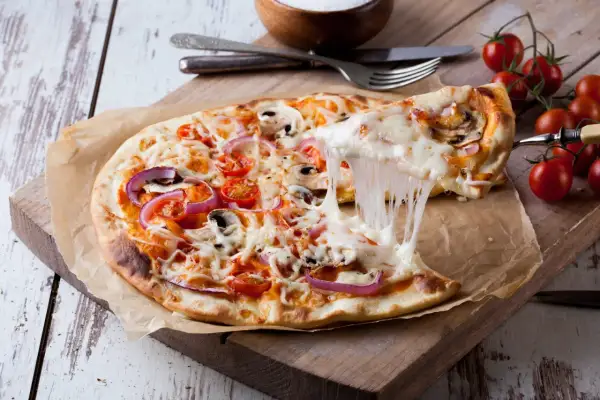 Rozciągający się ser z pizzy 32 cm z pomidorkami i cebulą. Zastanawiasz się, ile kcal ma pizza 32 cm?