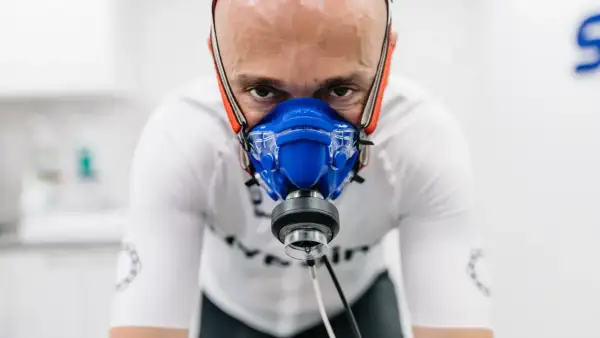Mężczyzna w masce do testów wysiłkowych, badający swoje VO2max.